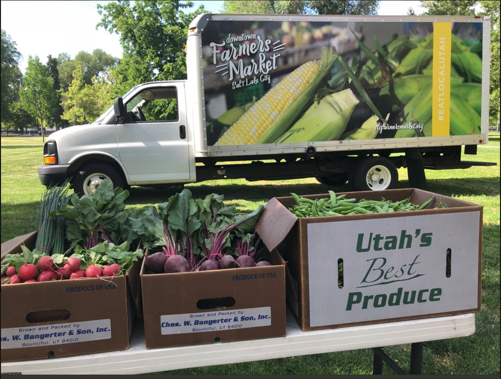 Photo of Downtown Farmers Market truck with boxed veggies in foreground.