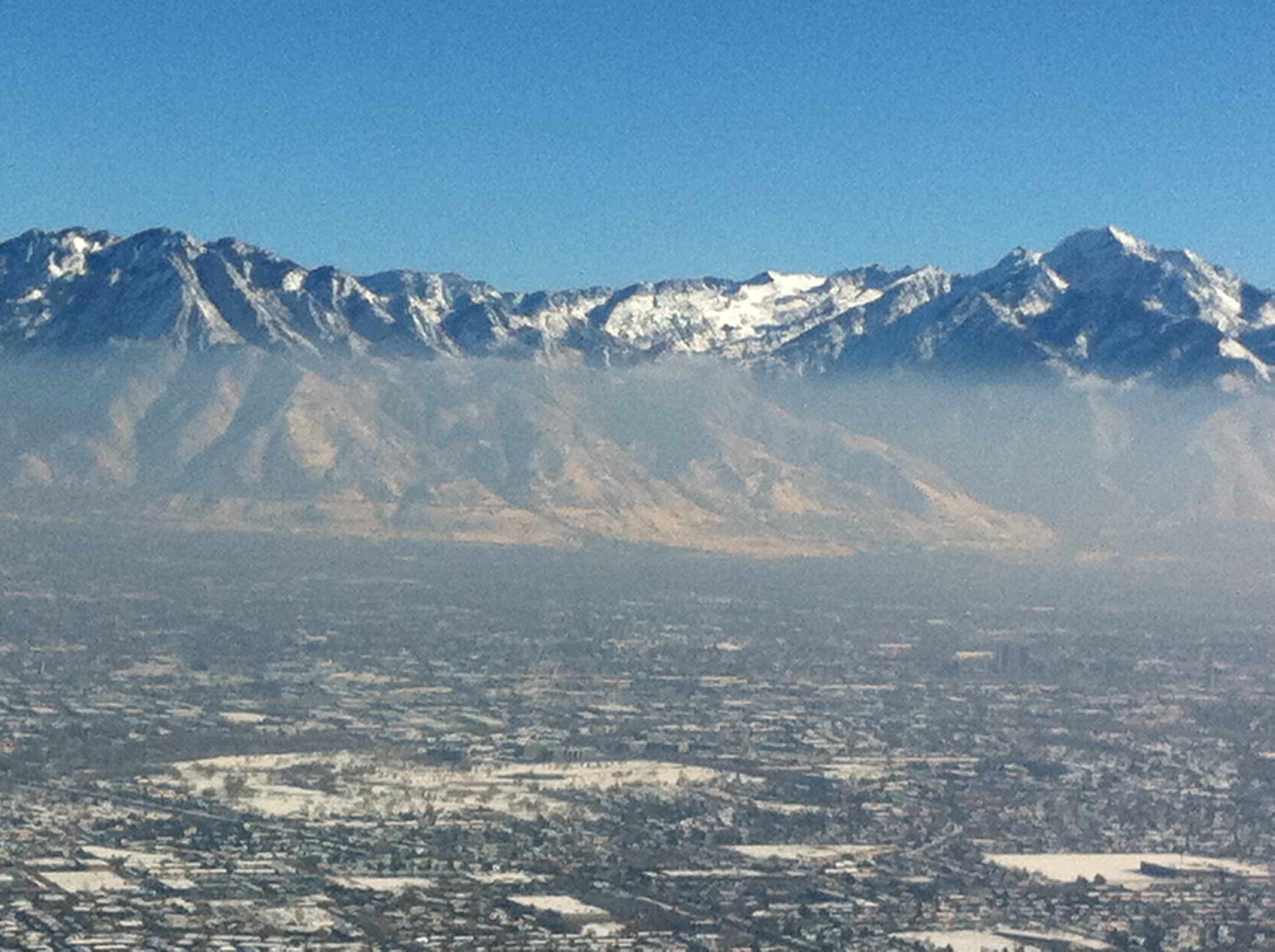 Photograph shows mountains with inversion hovering over valley.