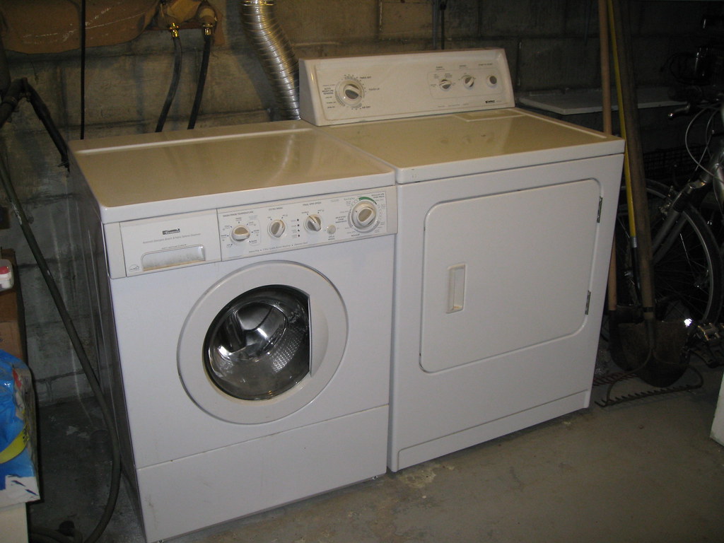 Photo of old washer and dryer in a basement. 
