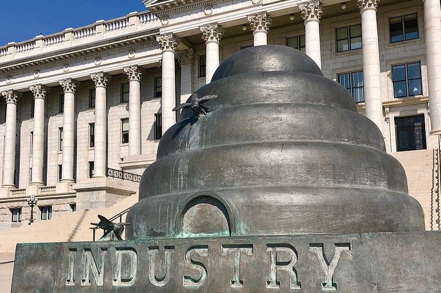 Image shows the beehive sculpture at the Utah State Capitol which reads 'Industry' at the base.