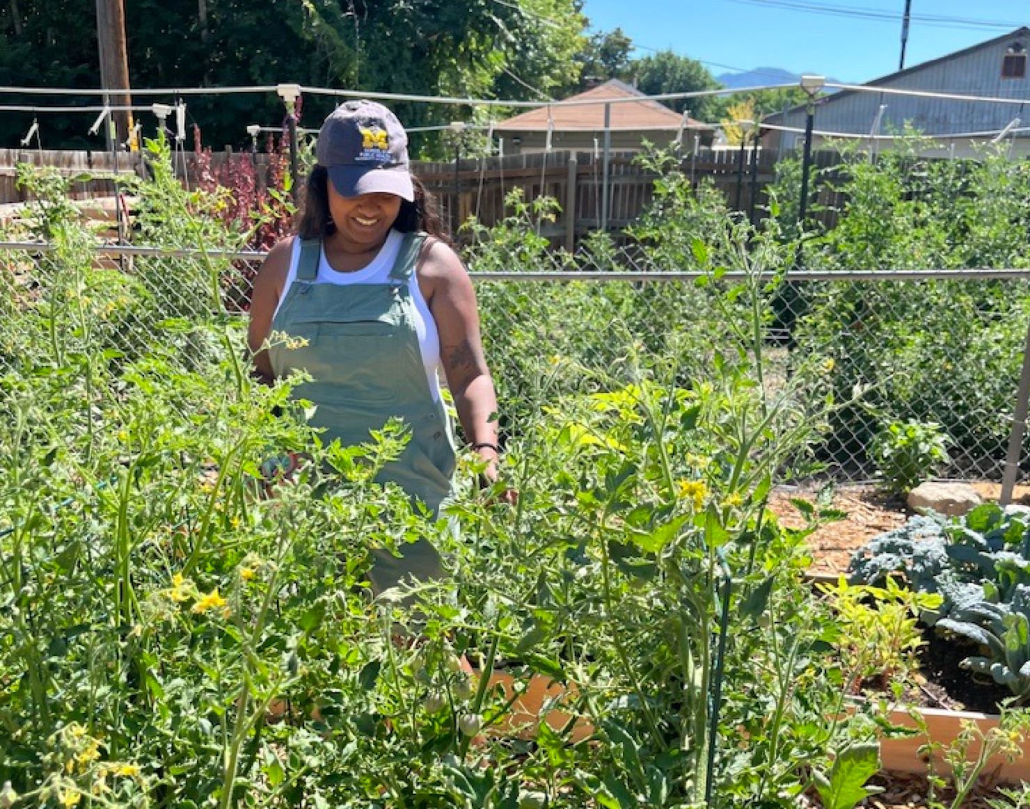 Priya Chidambaram, founder of Vanavil Gardens stands behind a garden bed in her backyard.